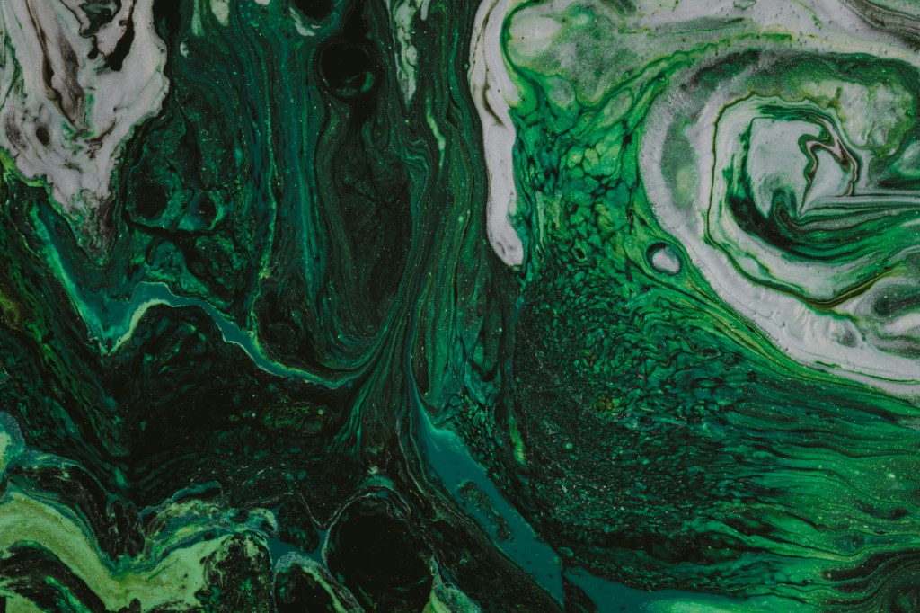 Image is color photo of a green-and-white swirl; title card for the new microfiction, "White," by Barbara Krasner.